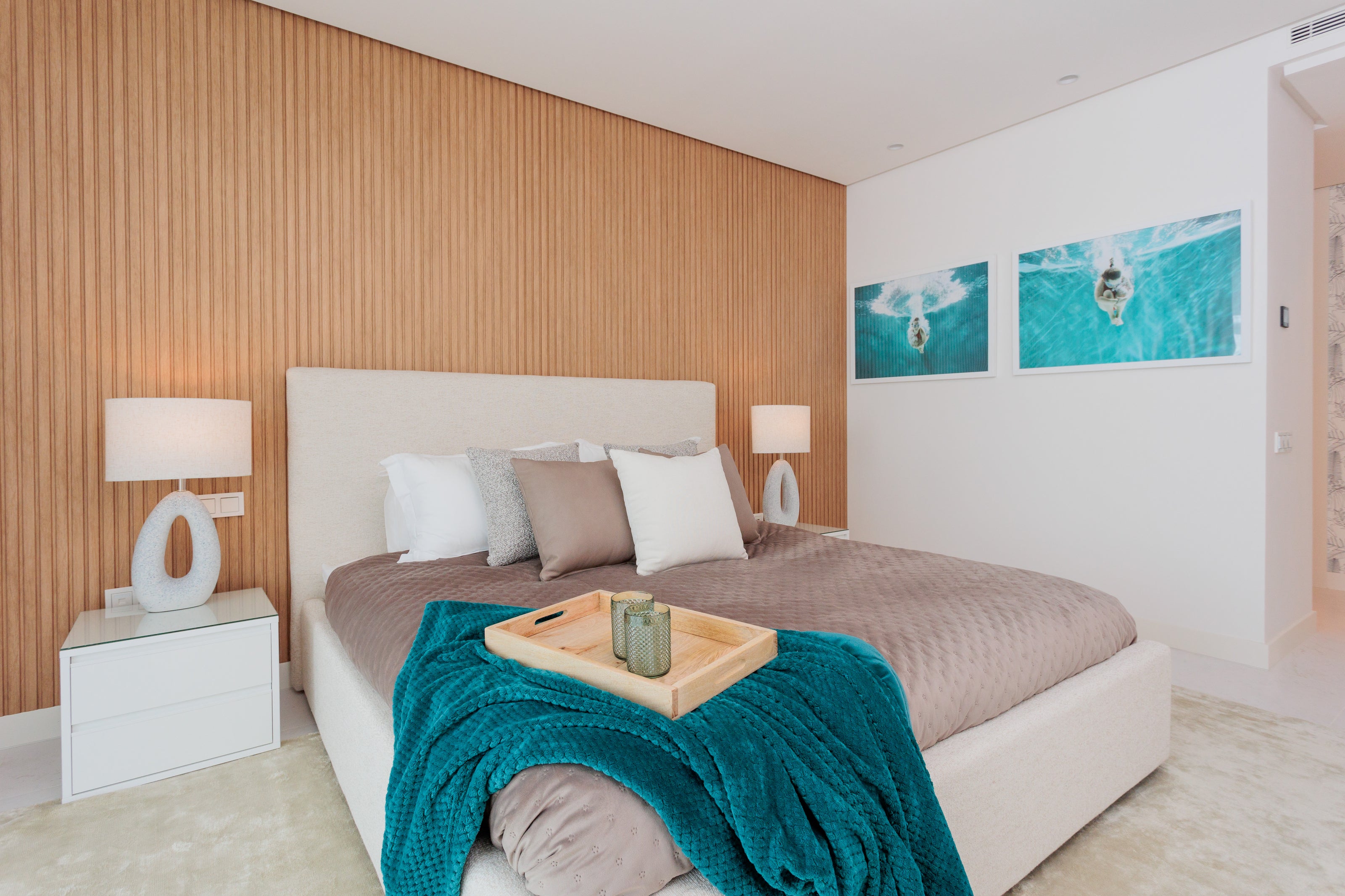 luxury elegant bedroom interior design with bed, headboard, bedroom table, table lamp, artworks green blue, rug available in el higueron, marbella, malaga, estepona, costa del sol.