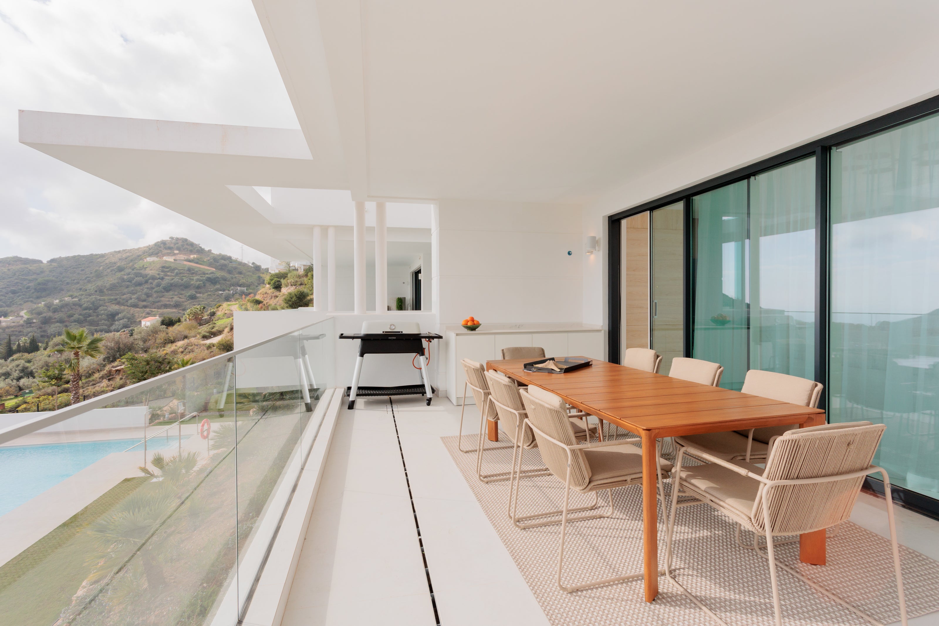 luxury modern outdoor living interior design with outdoor wooden dining table, outdoor chairs available in el higueron, marbella, malaga, estepona, costa del sol, bel air.