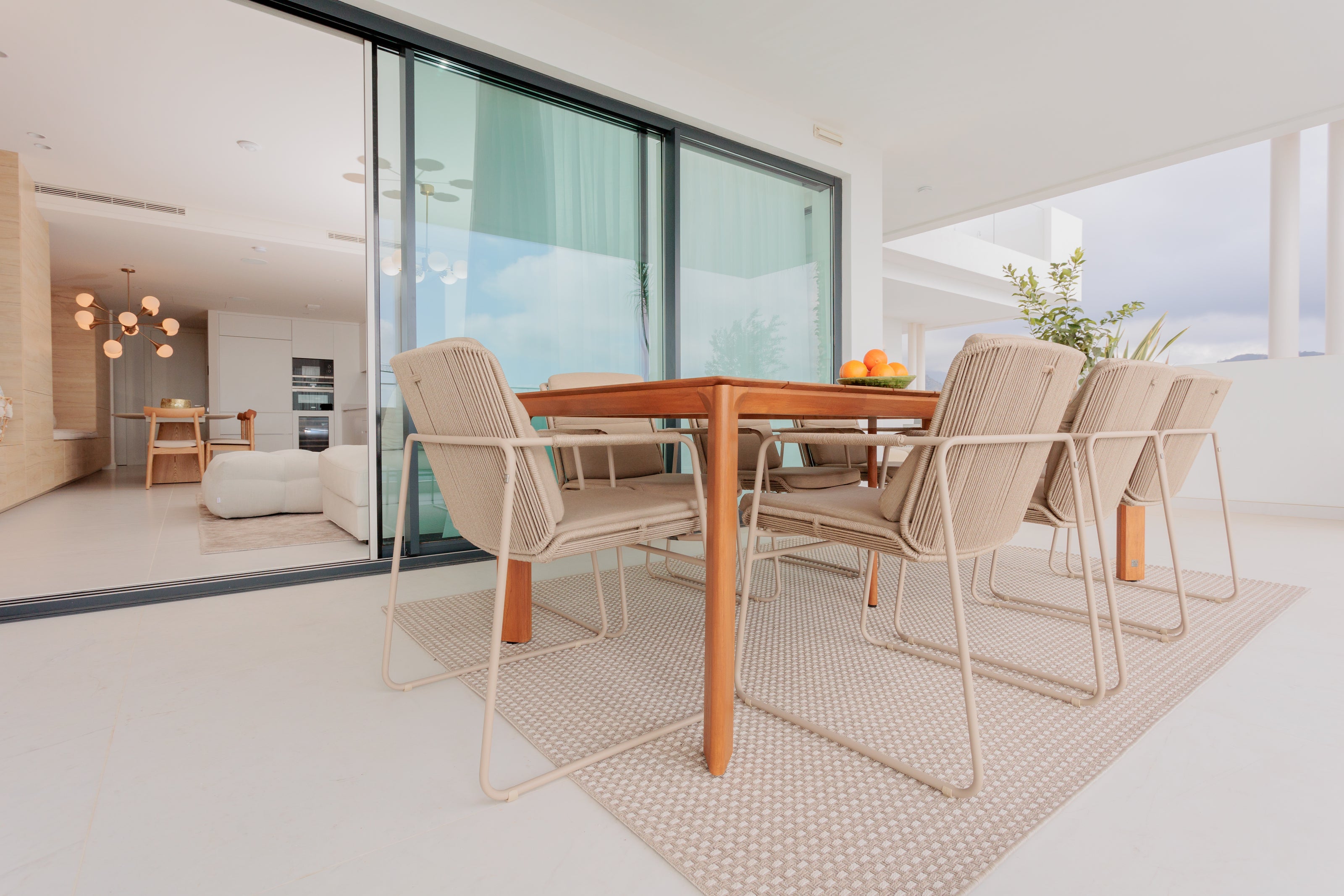 modern outdoor dining interior design, with wooden dining table, aluminium outdoor dining chairs, outdoor rug available in benahavis, marbella, malaga, costa del sol, bel air.