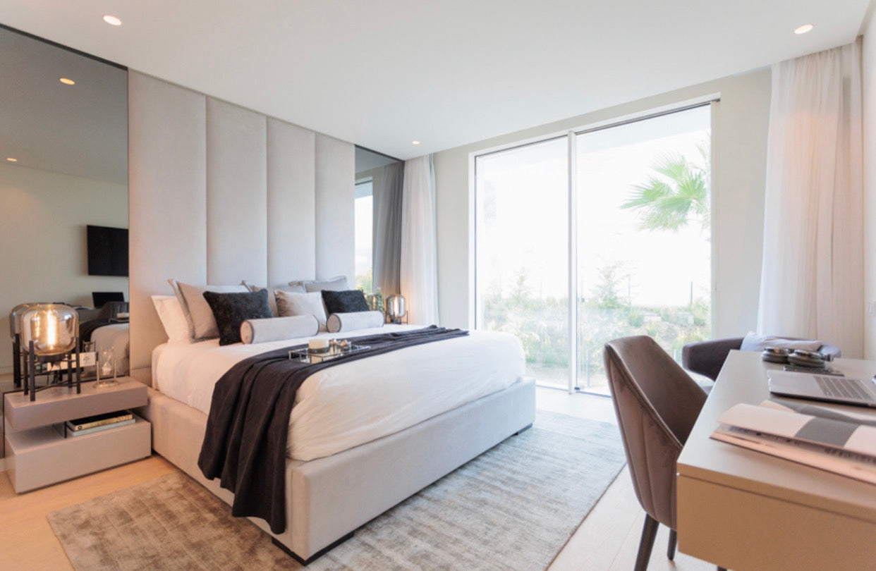 modern elegant interior design for bedroom with mirrors, bedd, bedside table, table lamps, rugs, desk, and chair available in bel air, alcazaba, marbella, malaga, costa del sol.