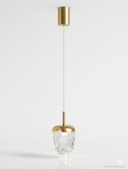 A modern pendant light fixture with a brushed gold cylindrical canopy and cap, a clear faceted crystal bowl, and a thin gold cord, shown against a plain white background.