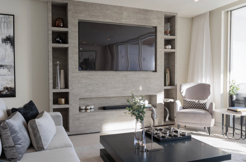 Modern living room with a television mounted on a wall with built-in shelves.